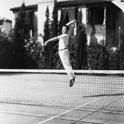 vintage tennis player jumping wearing whites